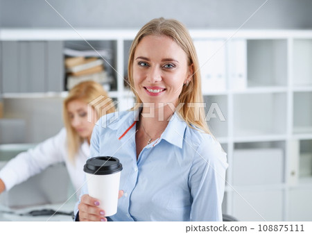 Smiling business woman drinking coffee Smiling business woman drinking coffee 108875111