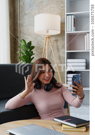 Happy girl checking social media holding smartphone sitting at sofa in living room at home. relaxing concepts 108875788