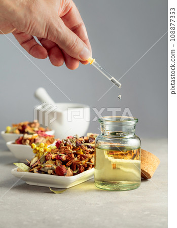 Dropping essential oil or herbal tincture into a glass bottle. 108877353