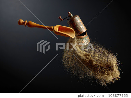 Pepper grinder and spoon with pepper ground. 108877363