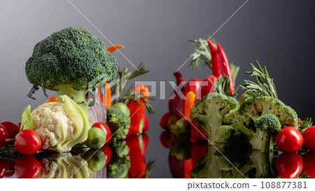 Various raw vegetables on a black reflective background. Various raw vegetables on a black reflective background. 108877381