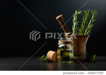 Bottle of rosemary aromatherapy oil extract with fresh rosemary branches. Bottle of rosemary aromatherapy oil extract with fresh rosemary branches. 108877393