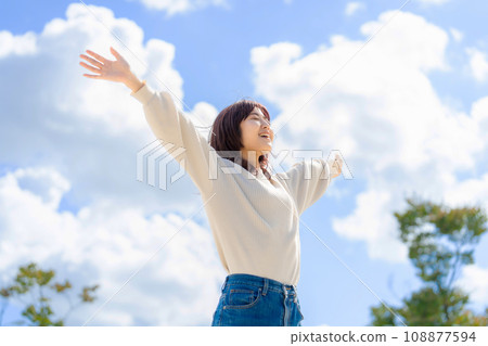 一個女人張開雙臂迎著藍天 一個女人張開雙臂迎著藍天 108877594