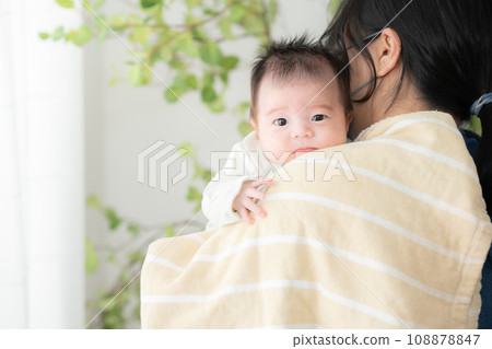 A mother burps her one-month-old cousin 108878847