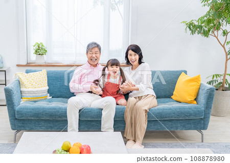 Grandparents and grandchildren relaxing in the living room Grandparents and grandchildren relaxing in the living room 108878980