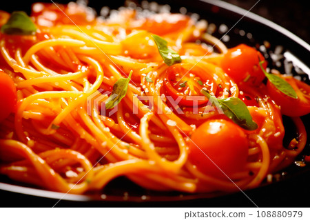 Top view of spaghetti pasta with tomato sauce, parmesan and mozzarella cheese decorated with basil on plate on table. Top view of spaghetti pasta with tomato sauce, parmesan and mozzarella cheese decorated with basil on plate on table. 108880979