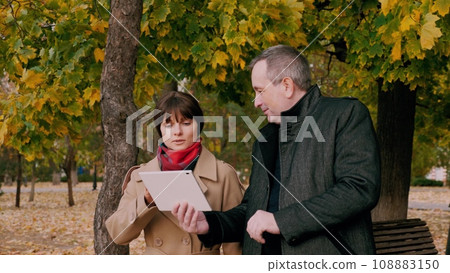 Man and woman employees of company discussing work related matters in park 108883150