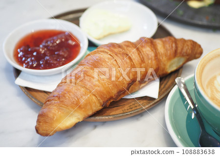 fresh baked croissant served with butter and jelly on table  108883638