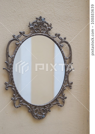 round mirror handing on a wall . round mirror handing on a wall . 108883639