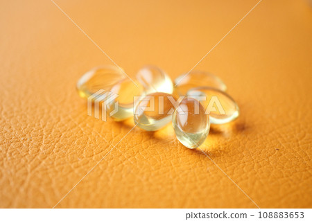 capsules from fish oil on orange color background capsules from fish oil on orange color background 108883653