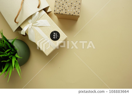 thank you sticker on a gift box on light yellow background  108883664