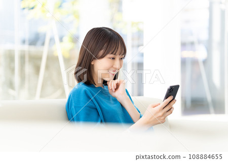 Smiling business woman looking at smartphone screen 108884655