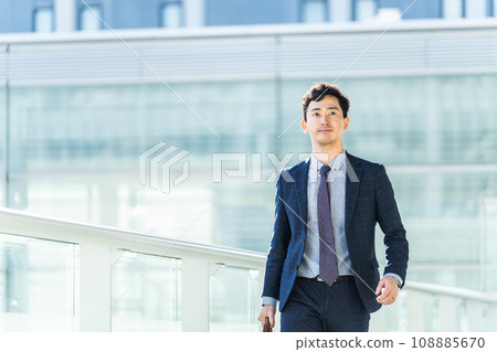 Male businessman walking dashingly through the office district Male businessman walking dashingly through the office district 108885670