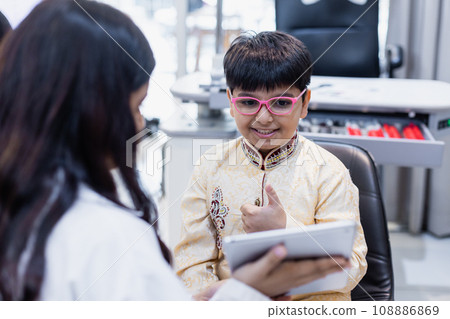 Happy Indian child boy wearing spectacles in glasses shop. 108886869