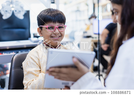 Happy Indian child boy wearing spectacles in glasses shop. 108886871