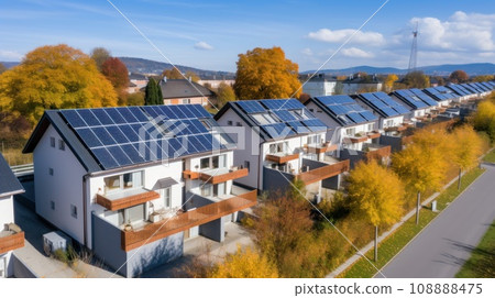 Eco-friendly apartment buildings with large solar panels on roofs surrounded by bright autumn trees 108888475