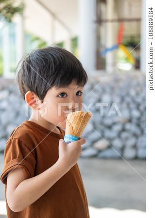 Little Asian boy eating delicious white chocolate ice cream 108889184