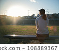 woman sitting on a park bench 108889367
