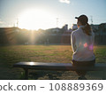 Woman sitting in the park in the evening 108889369