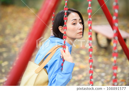 A woman killing time in the park 108891577
