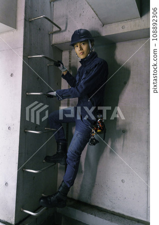 戴著頭盔、穿著工作服爬上屋頂樓梯的年輕人的肖像攝影合作:有明教育藝術學院 戴著頭盔、穿著工作服爬上屋頂樓梯的年輕人的肖像攝影合作:有明教育藝術學院 108892306