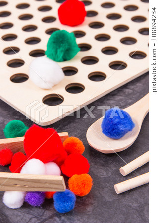 Colorful pompoms using for playing and development of kids motor skills Colorful pompoms using for playing and development of kids motor skills 108894234