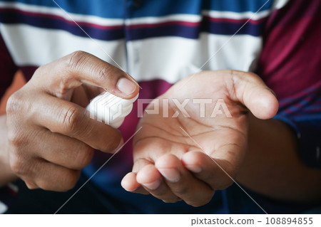 close up of young man hand using hand sanitizer spray. 108894855