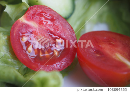 fresh cherry tomato slices on a plate  108894863