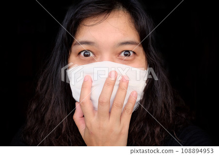 Asian Thai woman wearing a white cloth mask for prevent the Covid-19 or Corona virus in Thailand. She is serious and Coughing about Air Pollution Value Pm 2.5. Health and Respiratory system concept Asian Thai woman wearing a white cloth mask for prevent the Covid-19 or Corona virus in Thailand. She is serious and Coughing about Air Pollution Value Pm 2.5. Health and Respiratory system concept 108894953