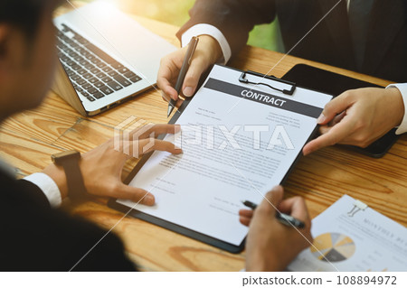 Male investor signing contract law conditions with his business partner at meeting 108894972