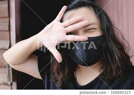 Asian Thai woman wearing a black cloth mask for prevent the Covid-19 or Corona virus and Epidemic disease at Thailand and around the world. Air pollution pm2.5. Health and illness concept 108895223
