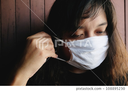 Asian Thai woman wearing a white cloth mask for prevent the Covid-19 or Corona virus and Air Pollution Value Pm 2.5 in Thailand and Epidemic disease around the world. Health and illnes Asian Thai woman wearing a white cloth mask for prevent the Covid-19 or Corona virus and Air Pollution Value Pm 2.5 in Thailand and Epidemic disease around the world. Health and illnes 108895230