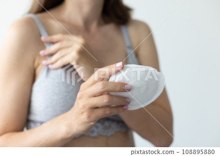 Woman with absorbent pad for breast for protect milk dripping. Closeup, selective focus. Woman with absorbent pad for breast for protect milk dripping. Closeup, selective focus. 108895880