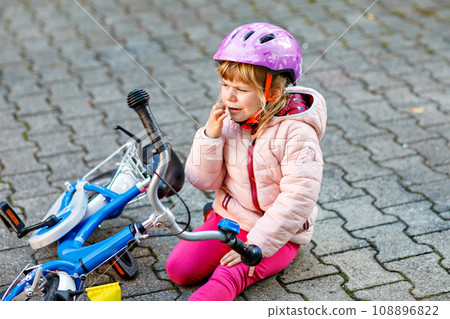Cute little girl sitting on the ground after... - Stock Photo [108896822] -  PIXTA