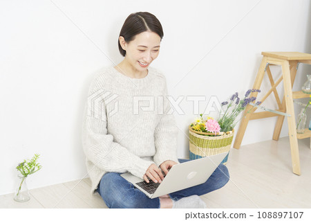 在客廳裡使用筆記本電腦的女士 108897107