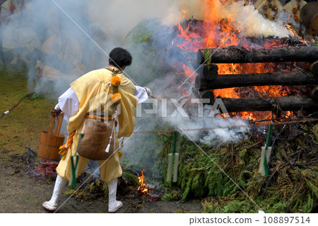 Choito Daigoma Shugendo adjusts the force of the flame by sprinkling water on it 108897514
