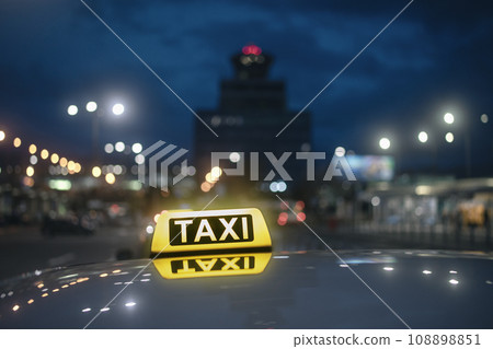 Close-up of taxi sign on car at night. Close-up of taxi sign on car at night. 108898851
