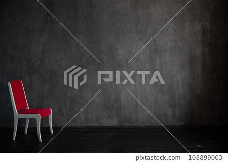 red chair in a dark room with a black background red chair in a dark room with a black background 108899003