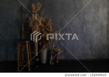shelf with decorative flowers chair in a dark room on a gray background 108899026