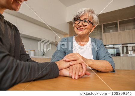 Happy family. Caring grown up daughter holding hands loving older woman mother. Young woman with mom grandmother enjoying arm bonding. Family generations together at home. Family moment love and care 108899145
