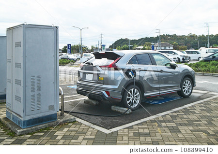 正在充電的電動車 (EV)(在路邊充電站的快速充電設施) 正在充電的電動車 (EV)(在路邊充電站的快速充電設施) 108899410