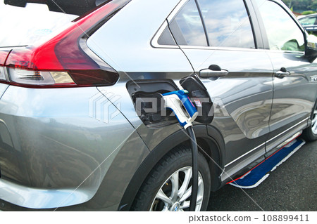 正在充電的電動車 (EV)(在路邊充電站的快速充電設施) 正在充電的電動車 (EV)(在路邊充電站的快速充電設施) 108899411