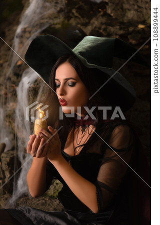 A portrait of a young sexy witch with outside. Magic, dark force, spell. Witchcraft. Halloween. A portrait of a young sexy witch with outside. Magic, dark force, spell. Witchcraft. Halloween. 108899444