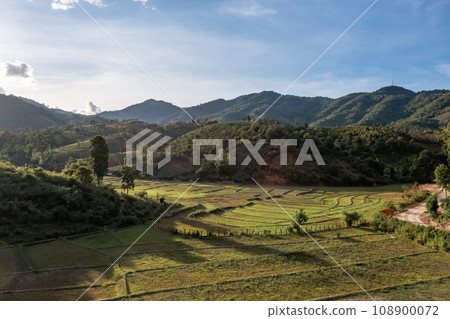 Aerial view of terraced agriculture field among greenery mountains with the blue cloudy and sunlight in the northern of Thailand, Omkoi district, Chiang Mai. Aerial view of terraced agriculture field among greenery mountains with the blue cloudy and sunlight in the northern of Thailand, Omkoi district, Chiang Mai. 108900072