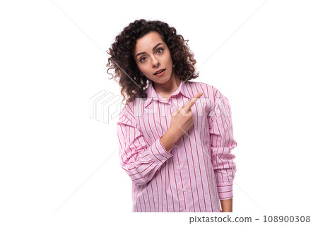 young cute curly-haired caucasian woman dressed in a striped pink blouse actively gesticulates with young cute curly-haired caucasian woman dressed in a striped pink blouse actively gesticulates with 108900308