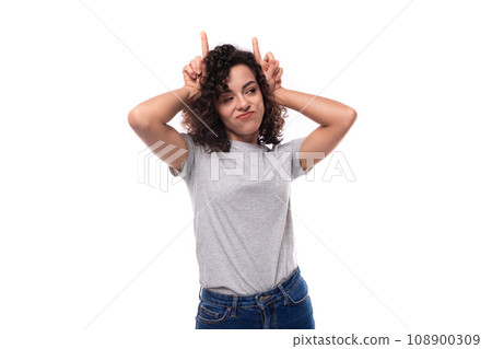 active bright curly woman with black hair dressed in a casual gray t-shirt with an identity print 108900309