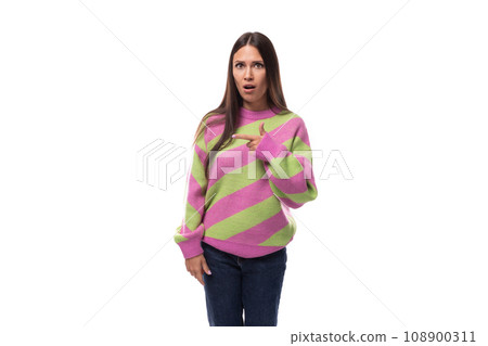 surprised pleasant young european brunette woman dressed in a striped pink-green pullover gesturing 108900311