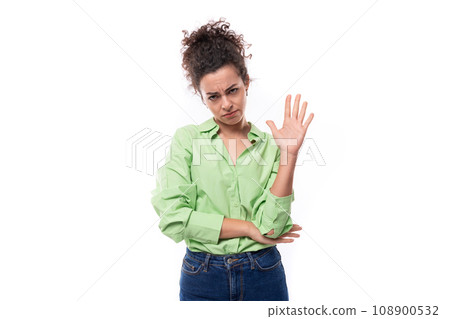 young smart slim european brunette curly woman with bun hairstyle dressed in green shirt and jeans 108900532