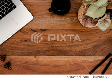 Wood desk office copy space with laptop, stationery and cup of tea, houseplant flat lay 108900979