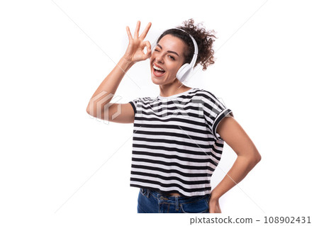 young caucasian woman with curly haircut dressed in a striped summer t-shirt enjoys listening to young caucasian woman with curly haircut dressed in a striped summer t-shirt enjoys listening to 108902431